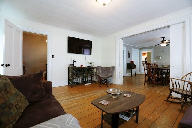 living room with wood-type flooring and ceiling fan