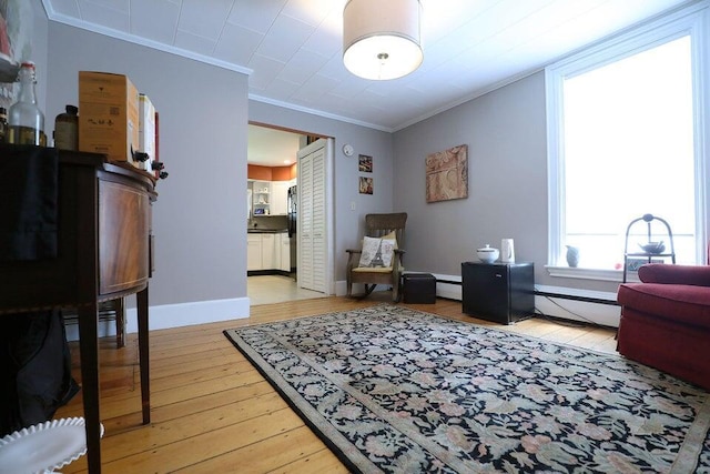 living area with light hardwood / wood-style floors, a baseboard radiator, and ornamental molding