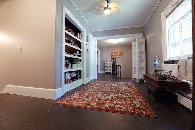 corridor with dark hardwood / wood-style floors, ornamental molding, and built in shelves