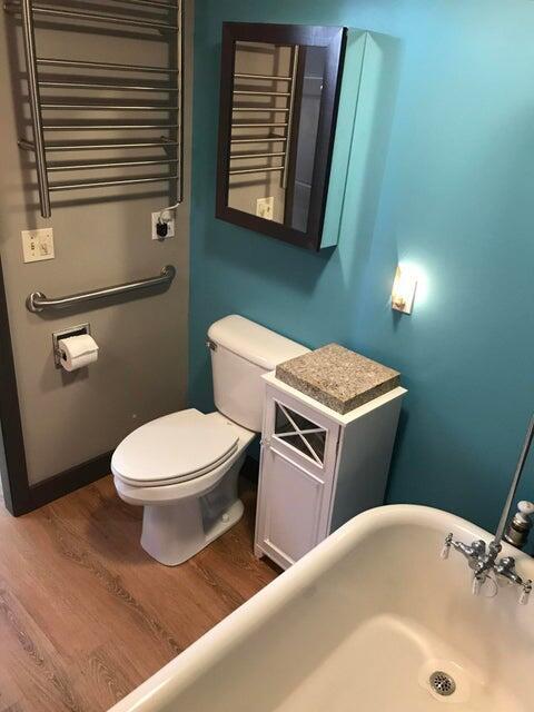 bathroom featuring radiator, toilet, and hardwood / wood-style flooring