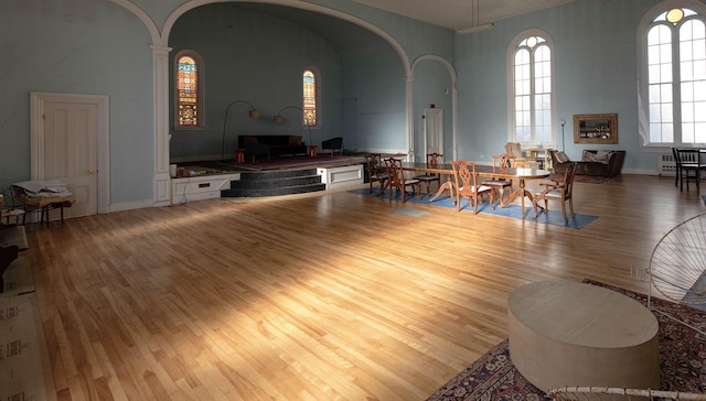 living room with a wealth of natural light, hardwood / wood-style floors, and a high ceiling