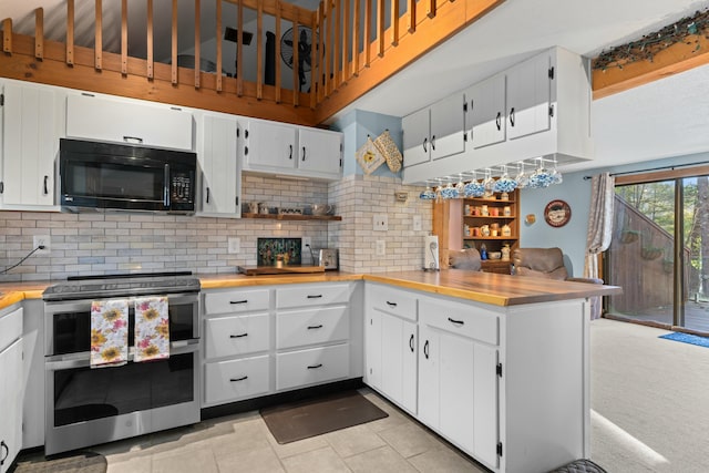 151 Mountain View Dr, Acton, ME 04001 - kitchen with decorative backsplash, kitchen peninsula, light tile patterned floors, range with two ovens, and white cabinetry