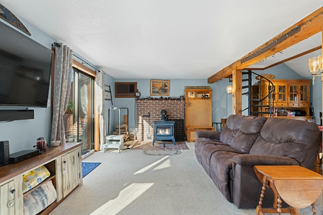 151 Mountain View Dr, Acton, ME 04001 - living room with a wood stove, vaulted ceiling with beams, a notable chandelier, an AC wall unit, and light carpet