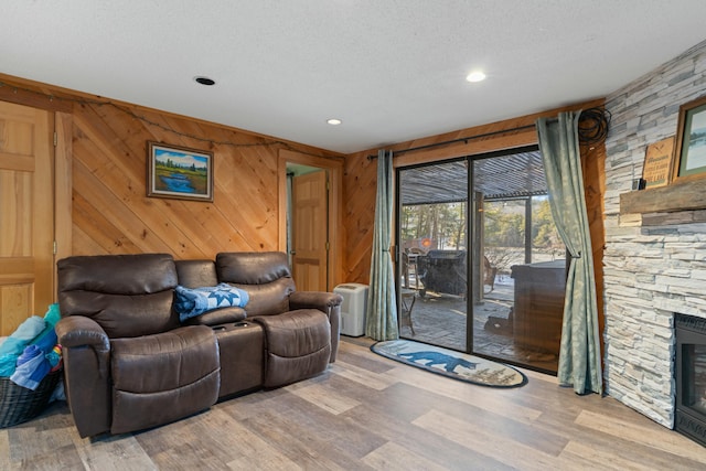 151 Mountain View Dr, Acton, ME 04001 - living room with wood walls, a fireplace, wood-type flooring, and a textured ceiling