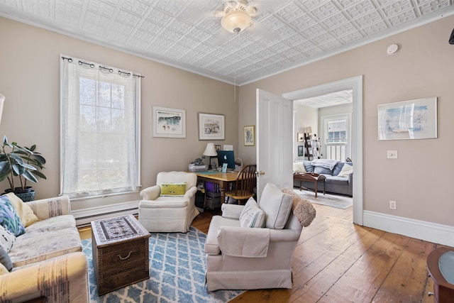 living room featuring wood-type flooring and a baseboard heating unit