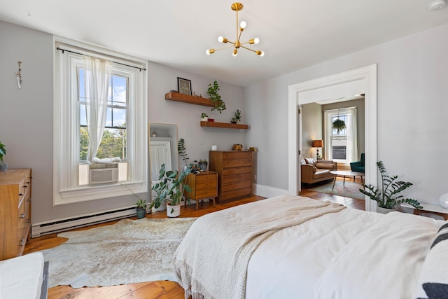 bedroom featuring hardwood / wood-style flooring, cooling unit, a chandelier, and a baseboard heating unit