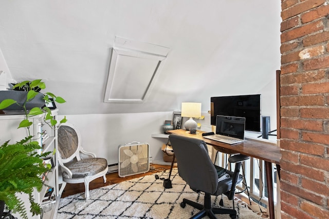 office with lofted ceiling, brick wall, and light hardwood / wood-style flooring