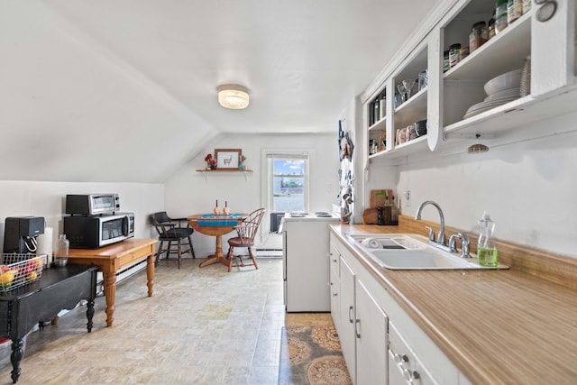 kitchen featuring white cabinets, sink, vaulted ceiling, and electric stove