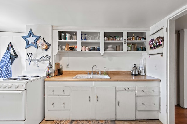 kitchen with white range oven, sink, and wooden counters