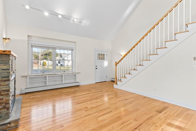 entryway featuring a fireplace, light hardwood / wood-style flooring, and a baseboard heating unit