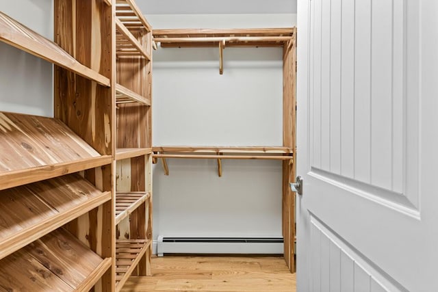 spacious closet featuring light hardwood / wood-style floors and baseboard heating