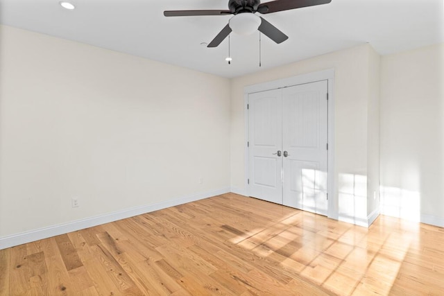 unfurnished bedroom with ceiling fan, a closet, and light hardwood / wood-style flooring