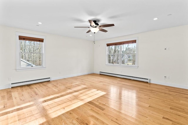 empty room with ceiling fan, light hardwood / wood-style flooring, and a baseboard heating unit