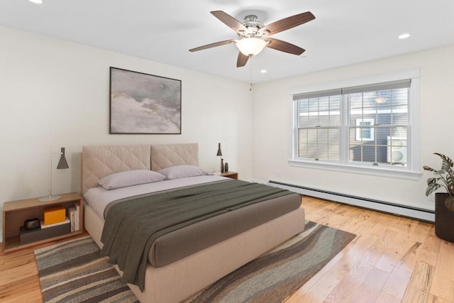 bedroom featuring a baseboard radiator, ceiling fan, and light hardwood / wood-style floors