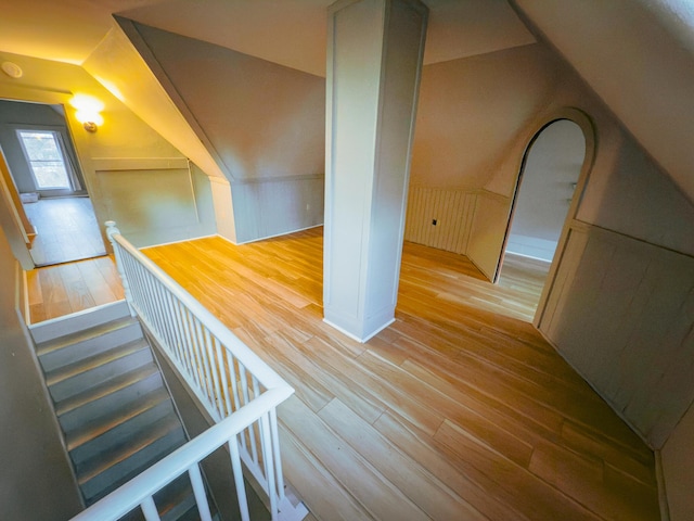 stairs with hardwood / wood-style floors and lofted ceiling