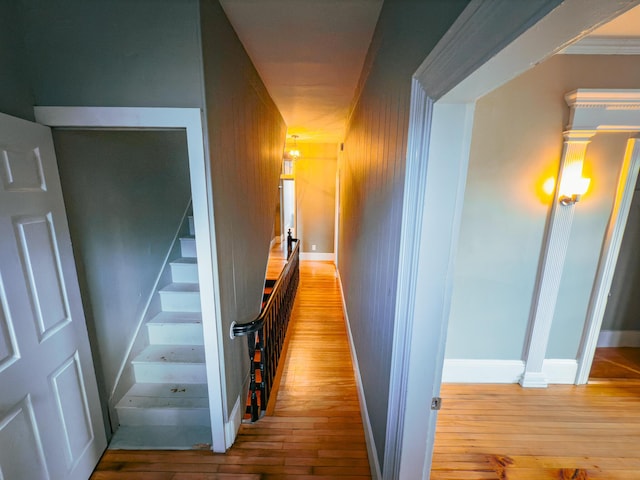 corridor with light hardwood / wood-style floors and crown molding