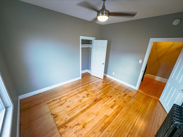 unfurnished bedroom featuring ceiling fan, light wood-type flooring, and a closet