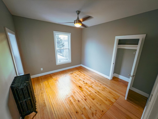 unfurnished bedroom with ceiling fan, light wood-type flooring, and a closet