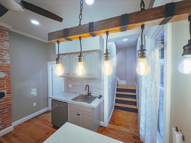 kitchen featuring stainless steel dishwasher, light wood-type flooring, sink, and tasteful backsplash