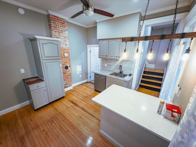 kitchen featuring gray cabinetry, sink, tasteful backsplash, stainless steel dishwasher, and crown molding