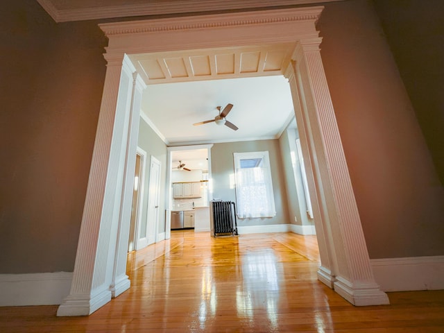 unfurnished living room with ornate columns, ceiling fan, light hardwood / wood-style flooring, and ornamental molding