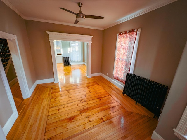 interior space featuring radiator, a wealth of natural light, light hardwood / wood-style flooring, and ornamental molding