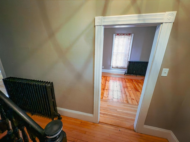 hallway featuring radiator heating unit and wood-type flooring