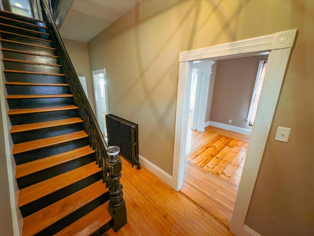 stairs featuring radiator and wood-type flooring