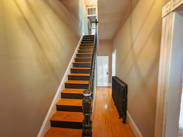 stairs with radiator heating unit and wood-type flooring