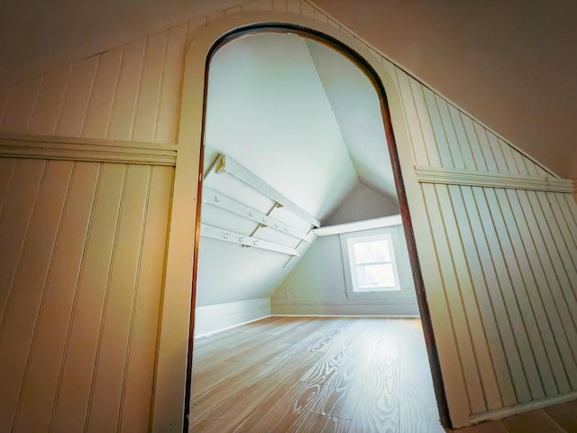 additional living space with light wood-type flooring and lofted ceiling