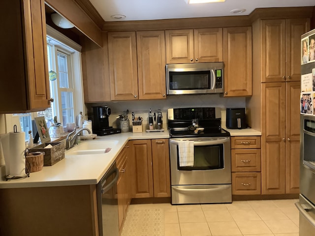 kitchen featuring light tile patterned flooring, stainless steel appliances, and sink