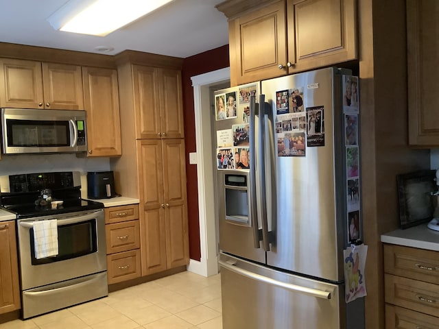 kitchen with light tile patterned floors and appliances with stainless steel finishes