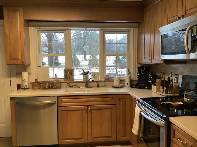 kitchen featuring decorative backsplash, stainless steel appliances, and sink