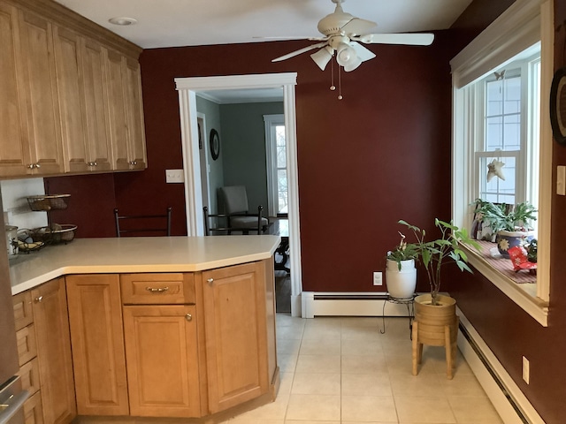 kitchen with a healthy amount of sunlight, light tile patterned floors, and a baseboard heating unit