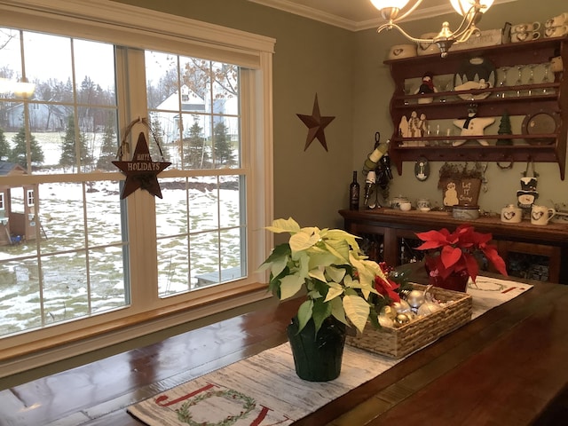 dining area with hardwood / wood-style floors, a notable chandelier, and crown molding