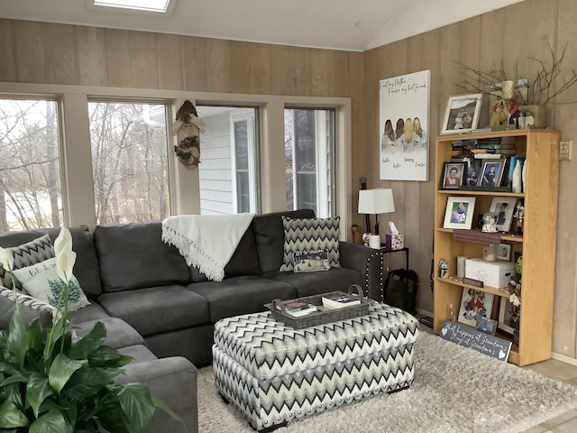 living room featuring vaulted ceiling and wood walls