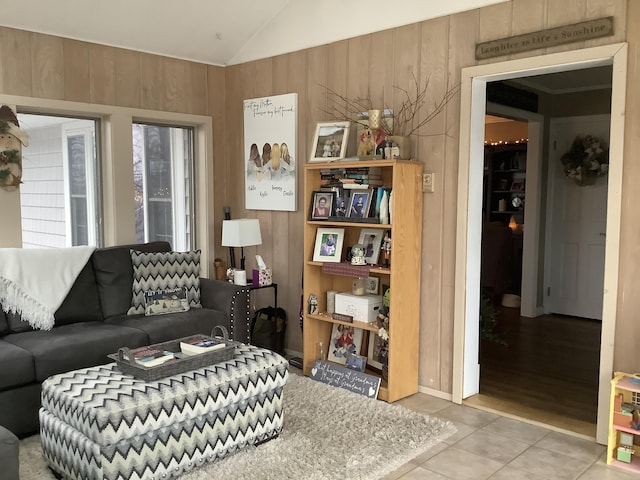 tiled living room featuring wood walls and vaulted ceiling