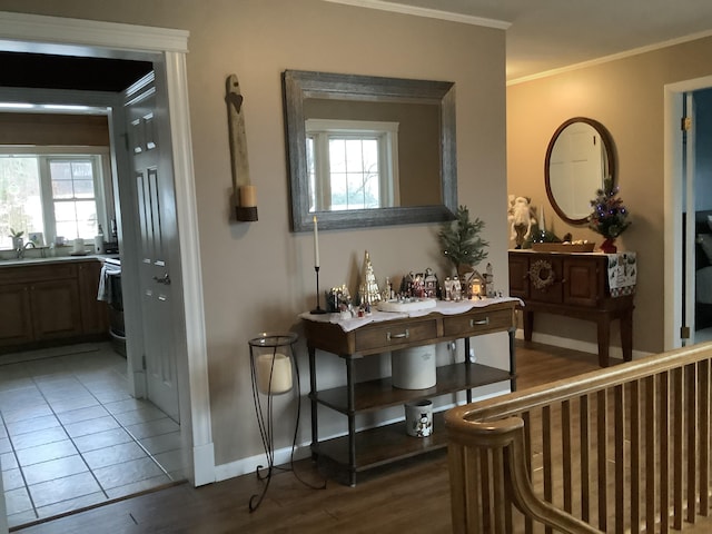 corridor featuring hardwood / wood-style floors, ornamental molding, and sink