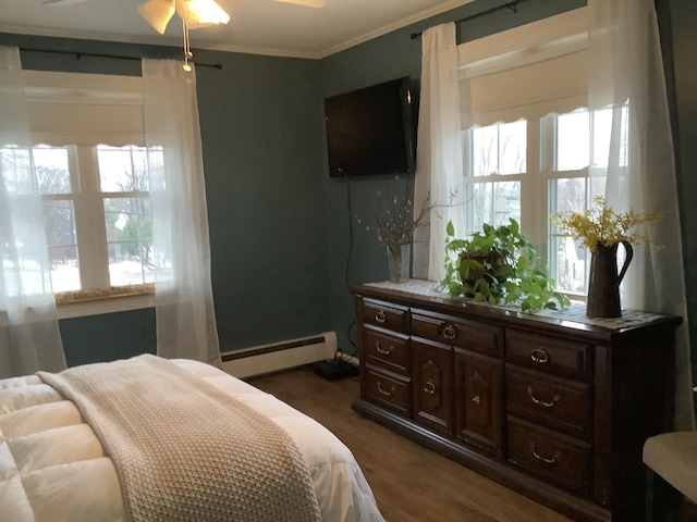 bedroom with ceiling fan, ornamental molding, dark wood-type flooring, and a baseboard heating unit