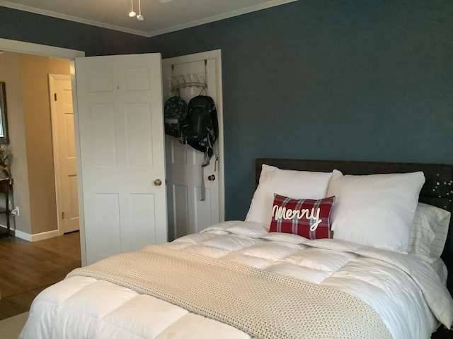 bedroom with wood-type flooring and crown molding