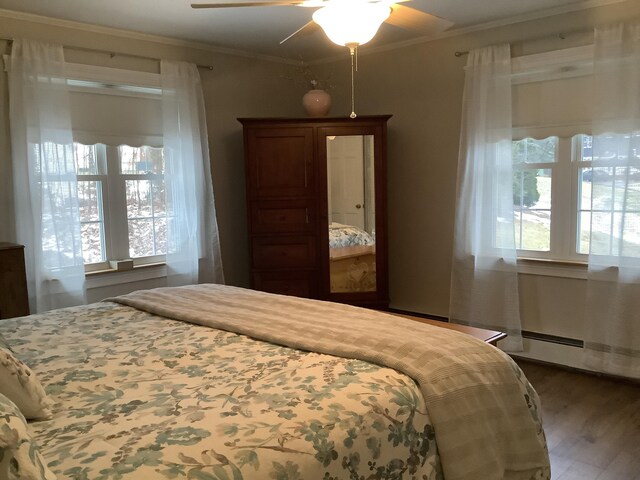 bedroom with multiple windows, ceiling fan, crown molding, and dark wood-type flooring