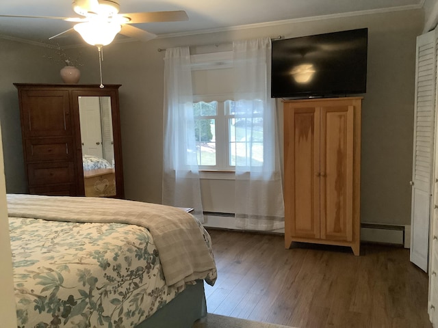 bedroom featuring dark hardwood / wood-style flooring, ceiling fan, crown molding, and a baseboard radiator