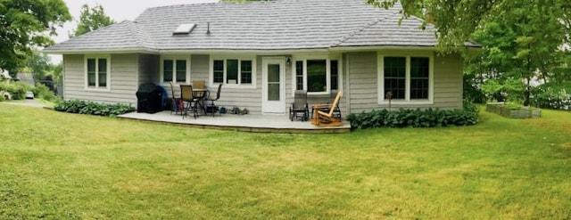 rear view of property featuring a yard and a patio area