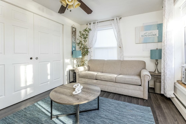 living room with ceiling fan and dark wood-type flooring