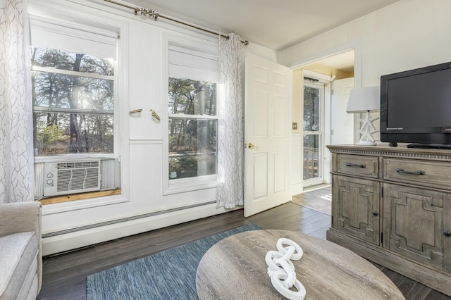 living area featuring dark wood-type flooring, cooling unit, and a baseboard radiator