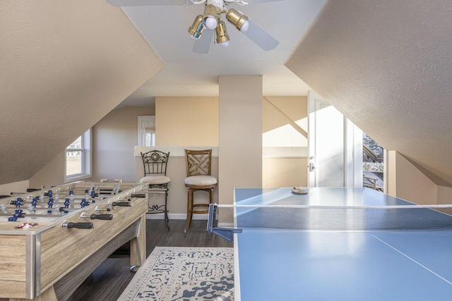 game room with ceiling fan, dark hardwood / wood-style flooring, and vaulted ceiling