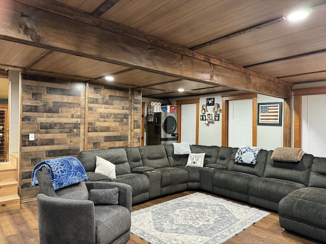 living area featuring wood ceiling, stacked washer / dryer, wood finished floors, and beam ceiling