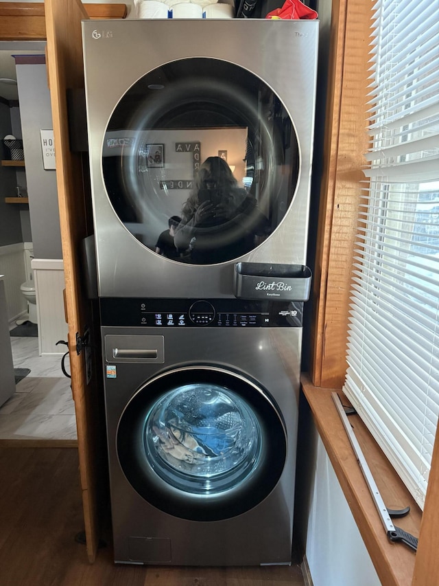 clothes washing area featuring laundry area and stacked washing maching and dryer