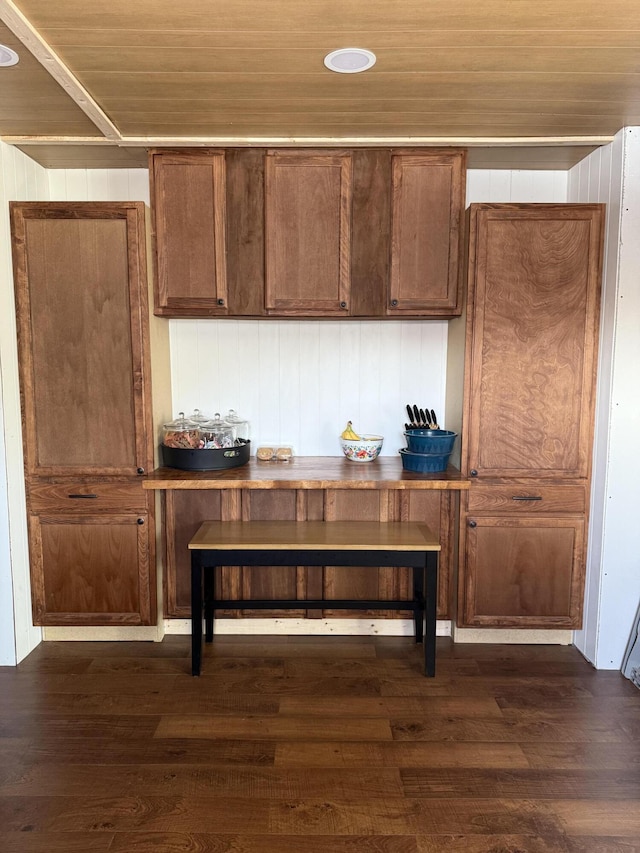 kitchen featuring dark wood-style floors, wood ceiling, and brown cabinetry