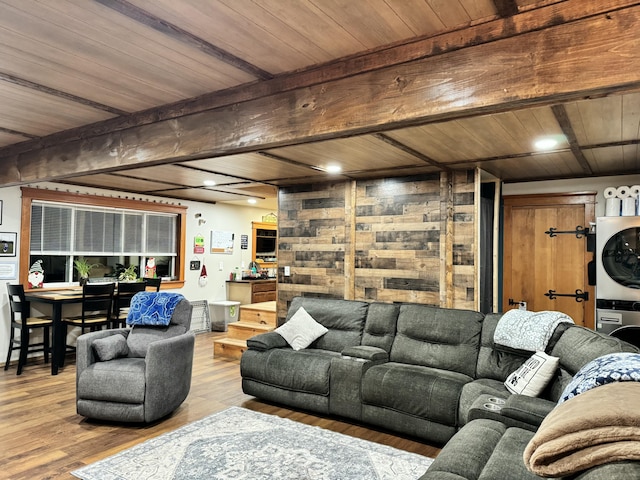 living area with wooden ceiling, recessed lighting, stacked washer / dryer, wood finished floors, and beam ceiling